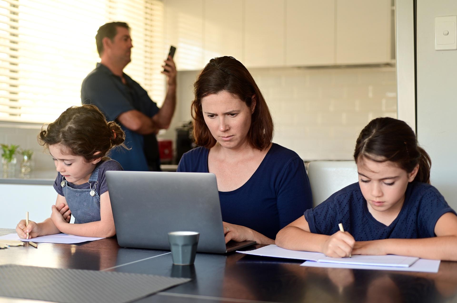 Mutter arbeitet am Laptop mit Kindern | Privatschule in Berlin