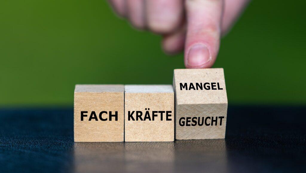 Holzwuerfel mit Aufschrift Fachkräftemangel Gesucht | Arbeitsrecht Würzburg