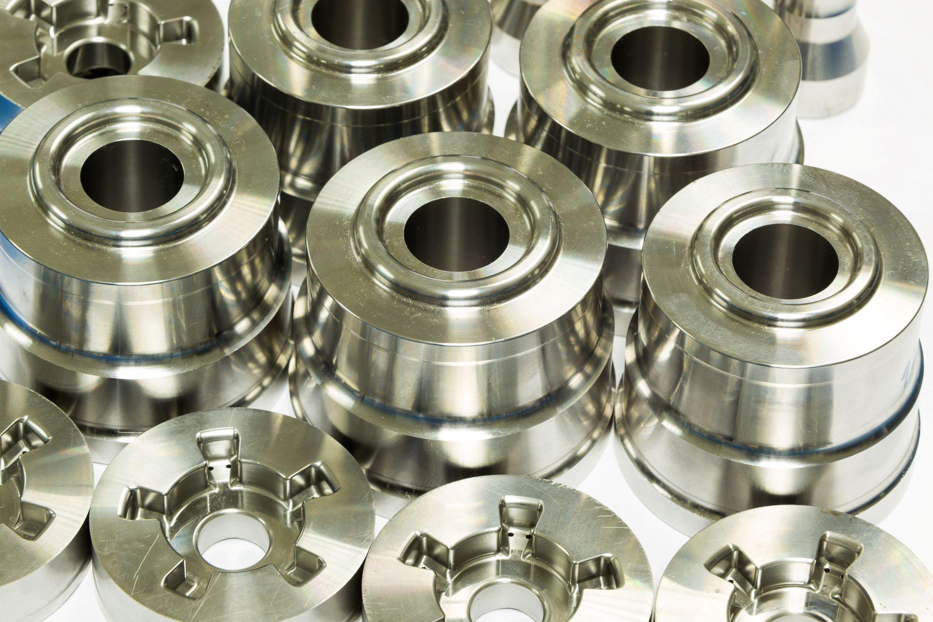 Mehrere glänzende Frästeile aus Metall, industriell gefräst